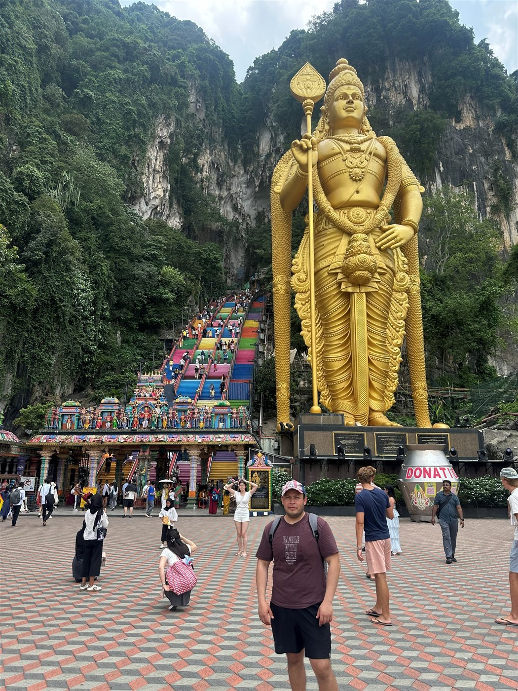 Edgar frente a la estatua dorada de Murugan y las escaleras de colores de las Cuevas Batu, en Malasia